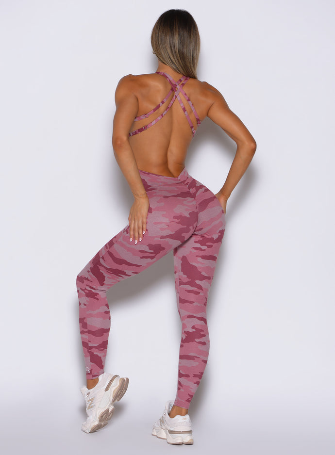 back profile view of a model wearing the Bombshell Bodysuit in Hibiscus camo color