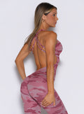 right side profile view of a model wearing the Bombshell Bodysuit in Hibiscus camo color