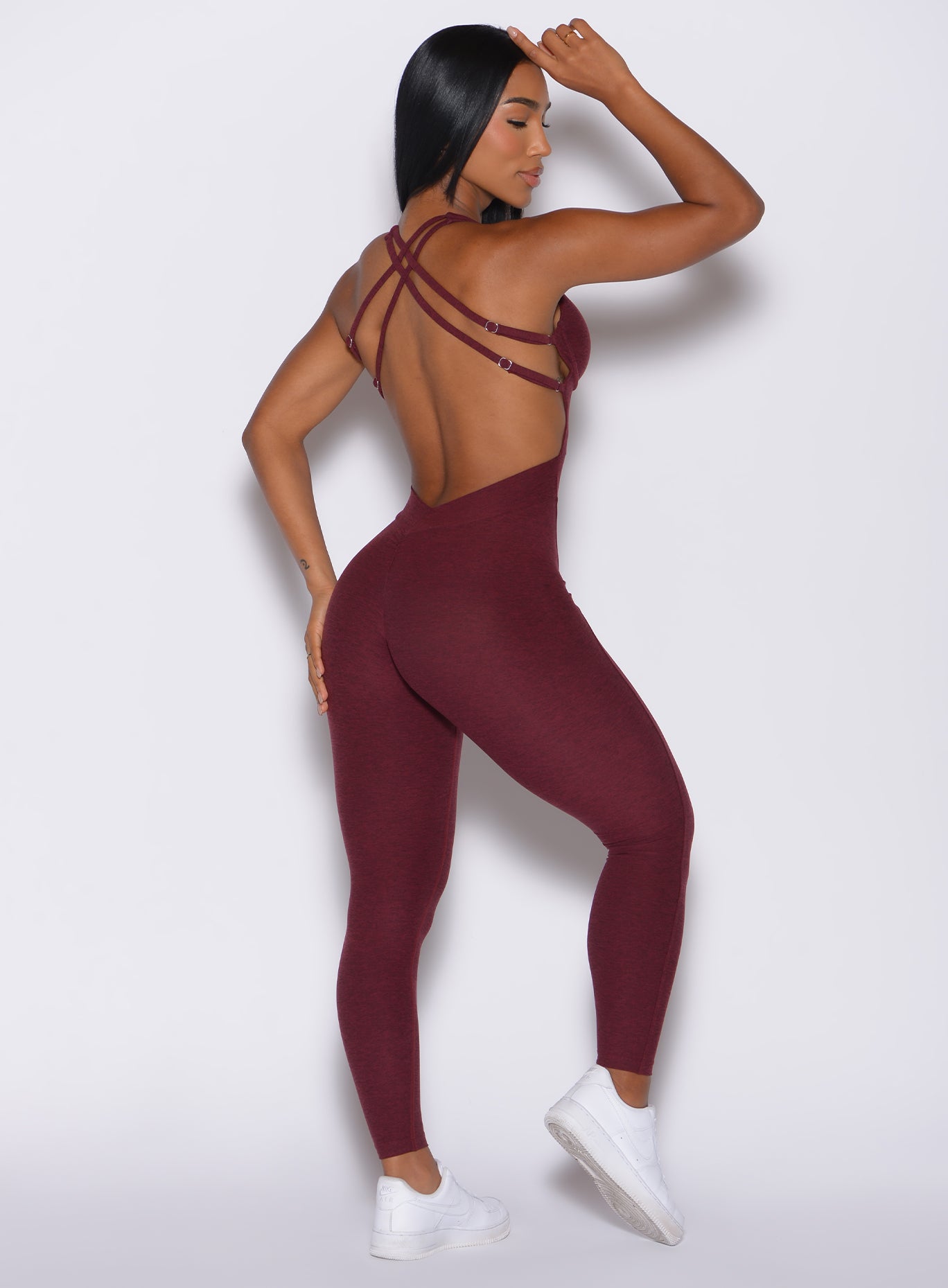 Back profile view of a model in our bombshell bodysuit in red wine color
