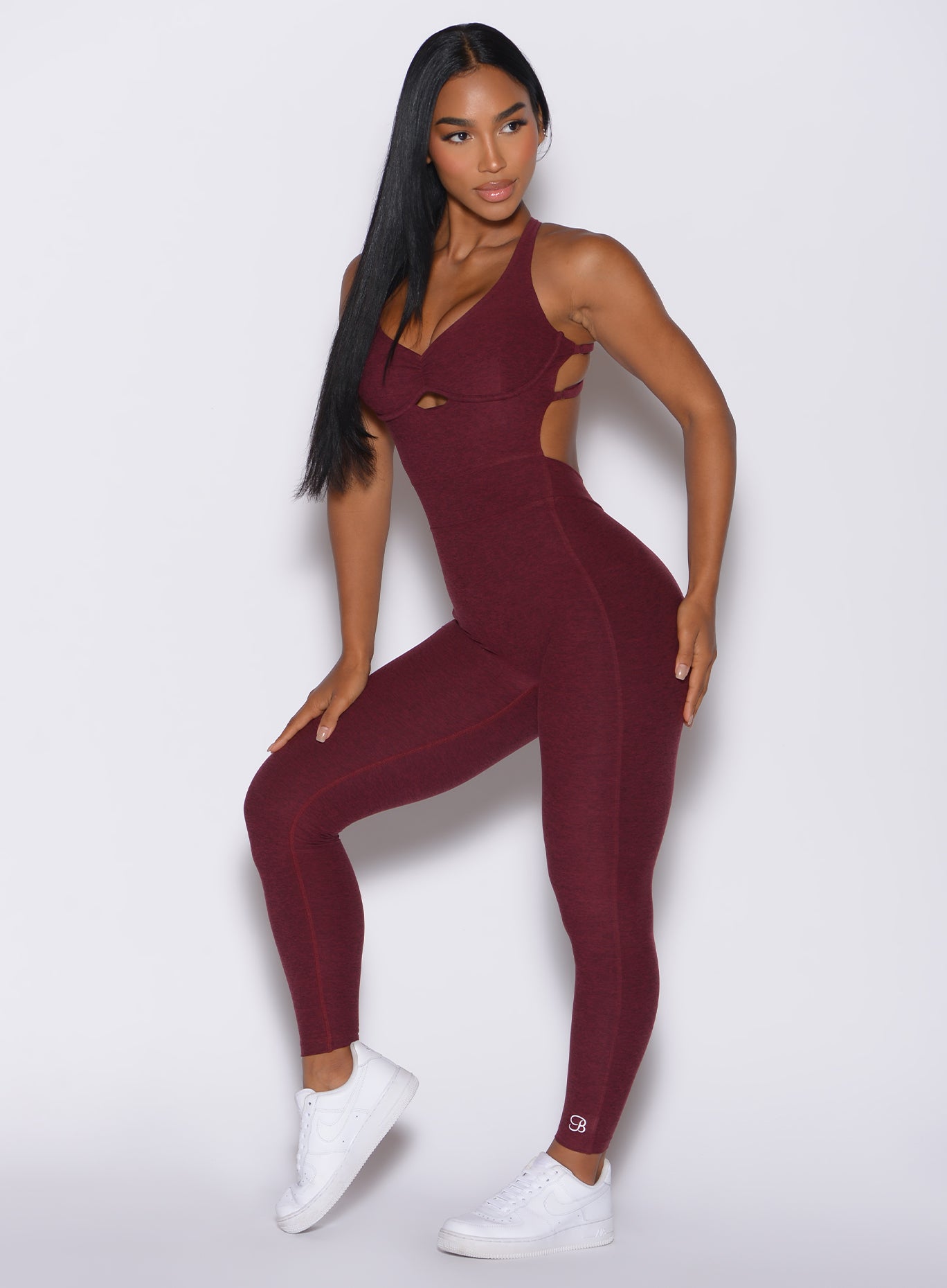 Front profile view of a model wearing our bombshell bodysuit in red wine color