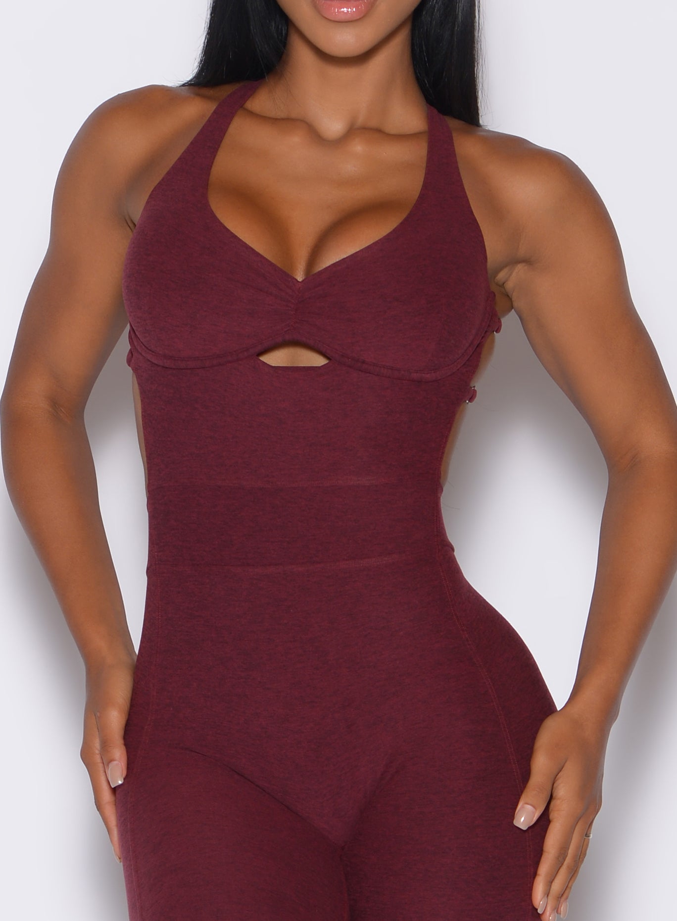 Zoomed in profile view of a model in our bombshell bodysuit in red wine color