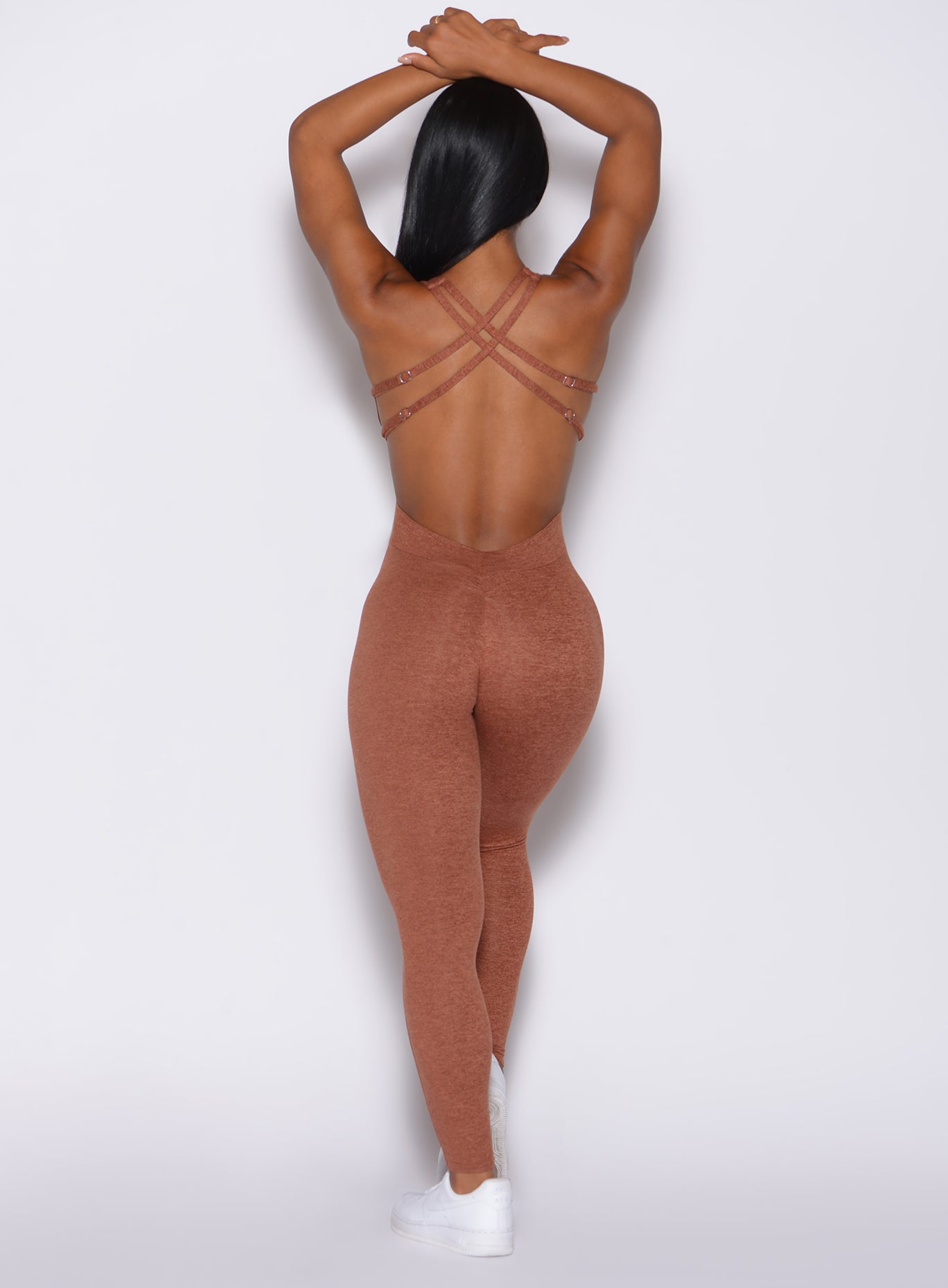 Back profile view of a model in our bombshell bodysuit in spiced chai color