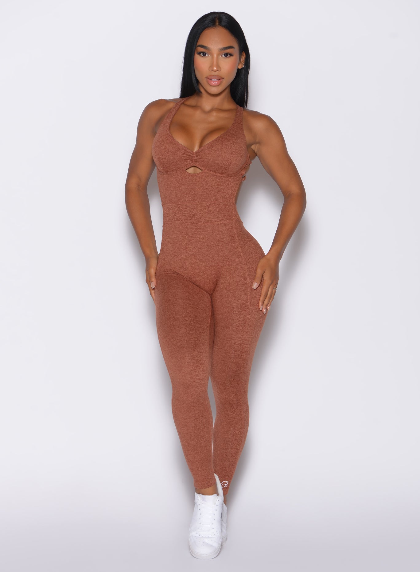 Front profile view of a model facing forward wearing our bombshell bodysuit in spiced chai color