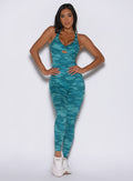front profile view of a model with both hands on her waist wearing the Bombshell Bodysuit in Teal camo color
