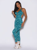 front left side profile view of a model wearing the Bombshell Bodysuit in Teal camo color