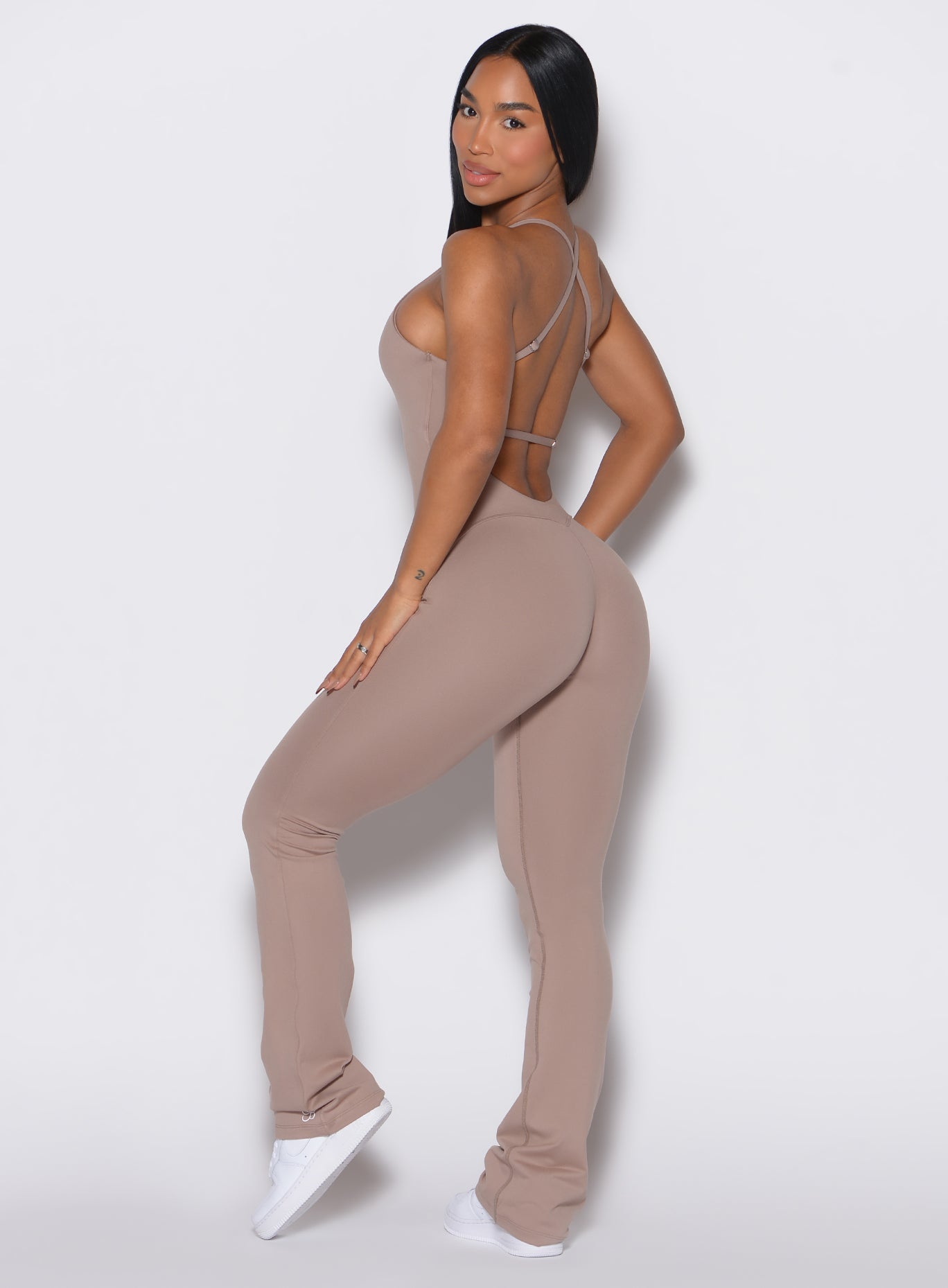Left profile view of a model wearing the Bombshell Bunny Bodysuit in Clay color.