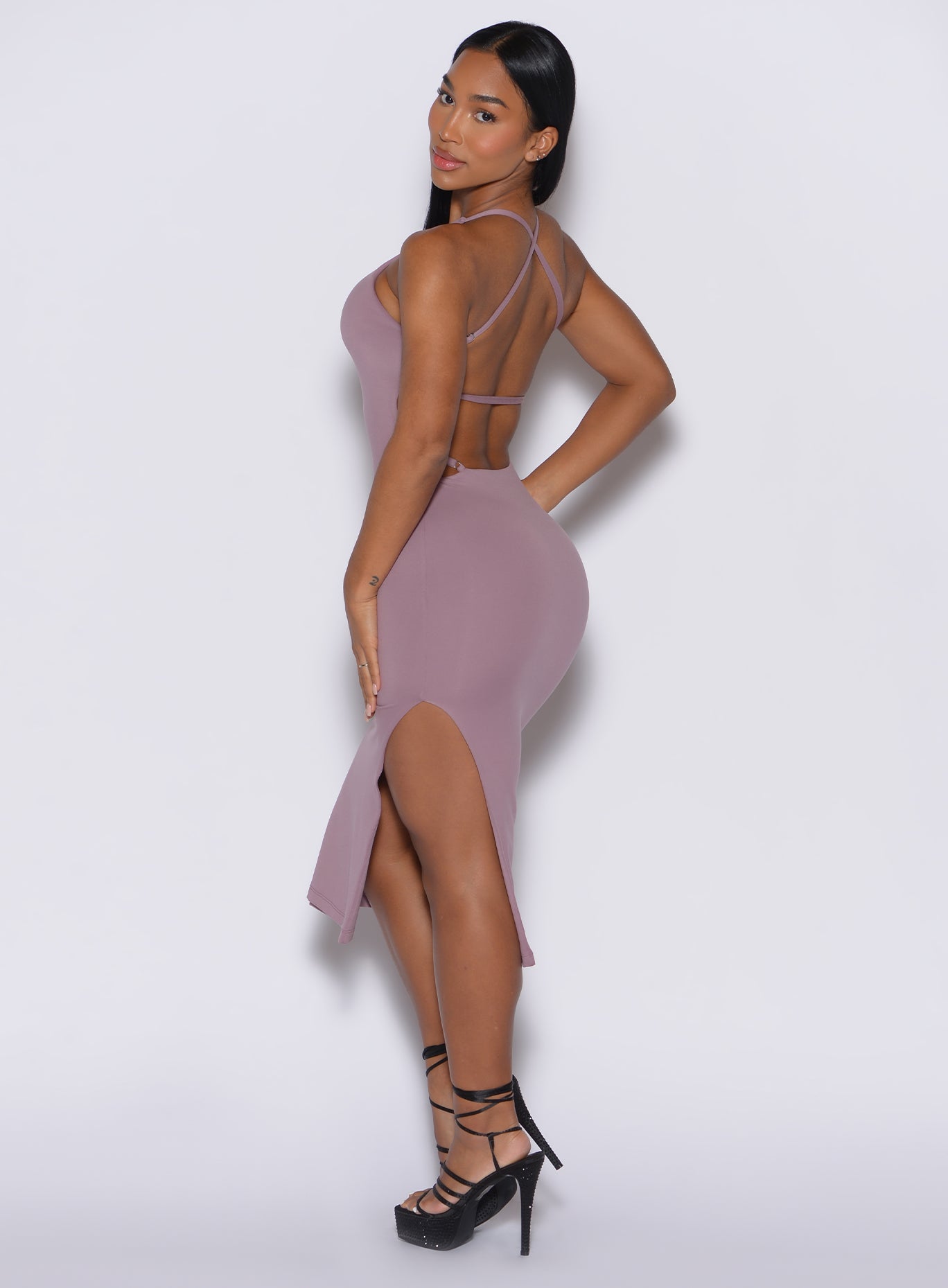 left side profile view of a model facing to her left  wearing our bombshell bunny dress in light mauve color