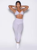 front profile view of a model in a hair tying pose wearing the Bombshell Bunny Leggings in Galactic Lilac color