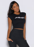 front view of a model looking to the left side wearing the Bombshell Era Tee in black color 