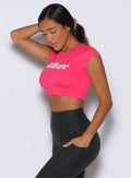 front left side profile view of a model holding her hair with one hand wearing the Bombshell Era Tee in solid victory ruby color 