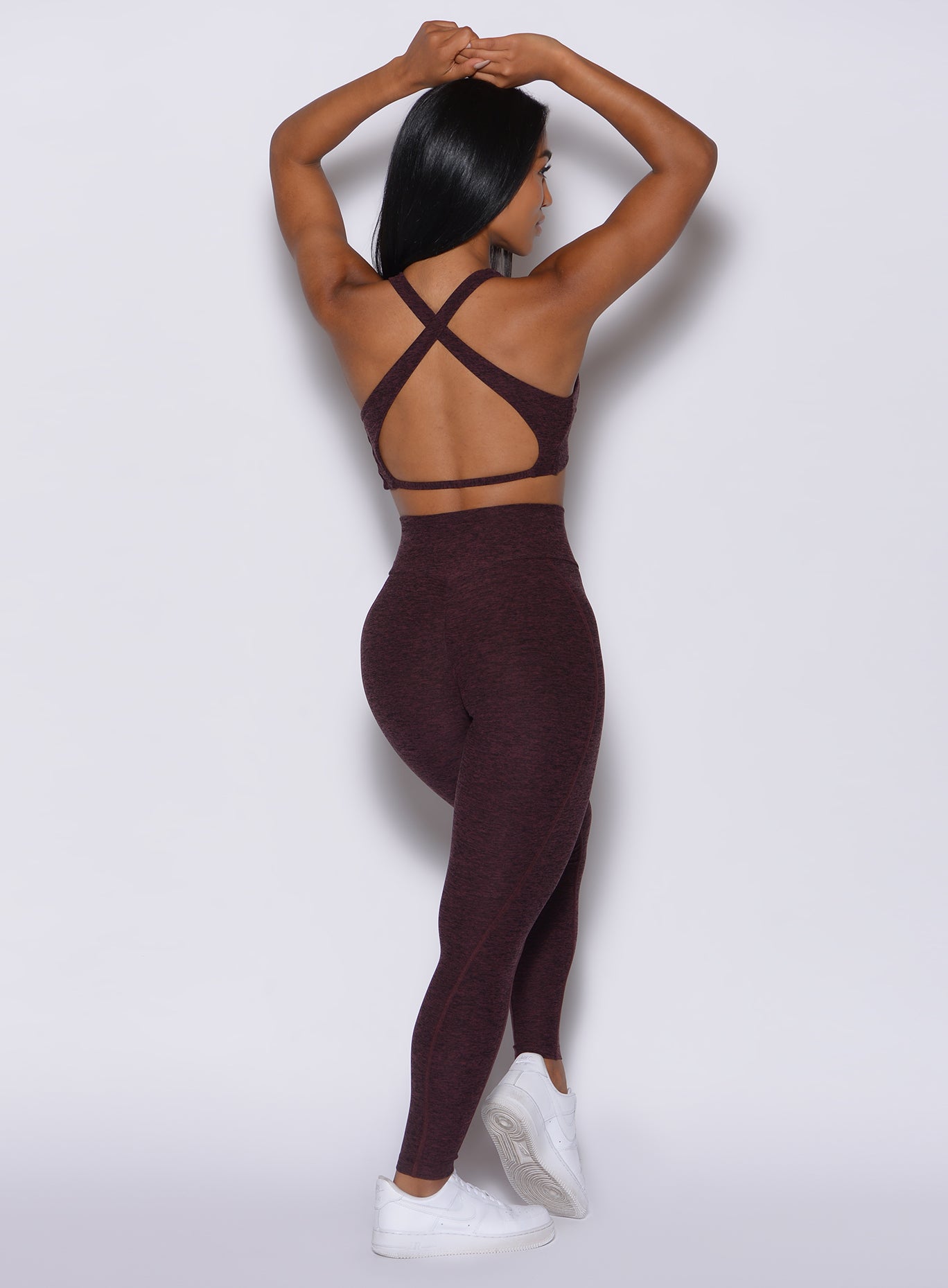 back profile view of a model facing to her right wearing our Brazilian Contour Leggings in port color and a matching bra