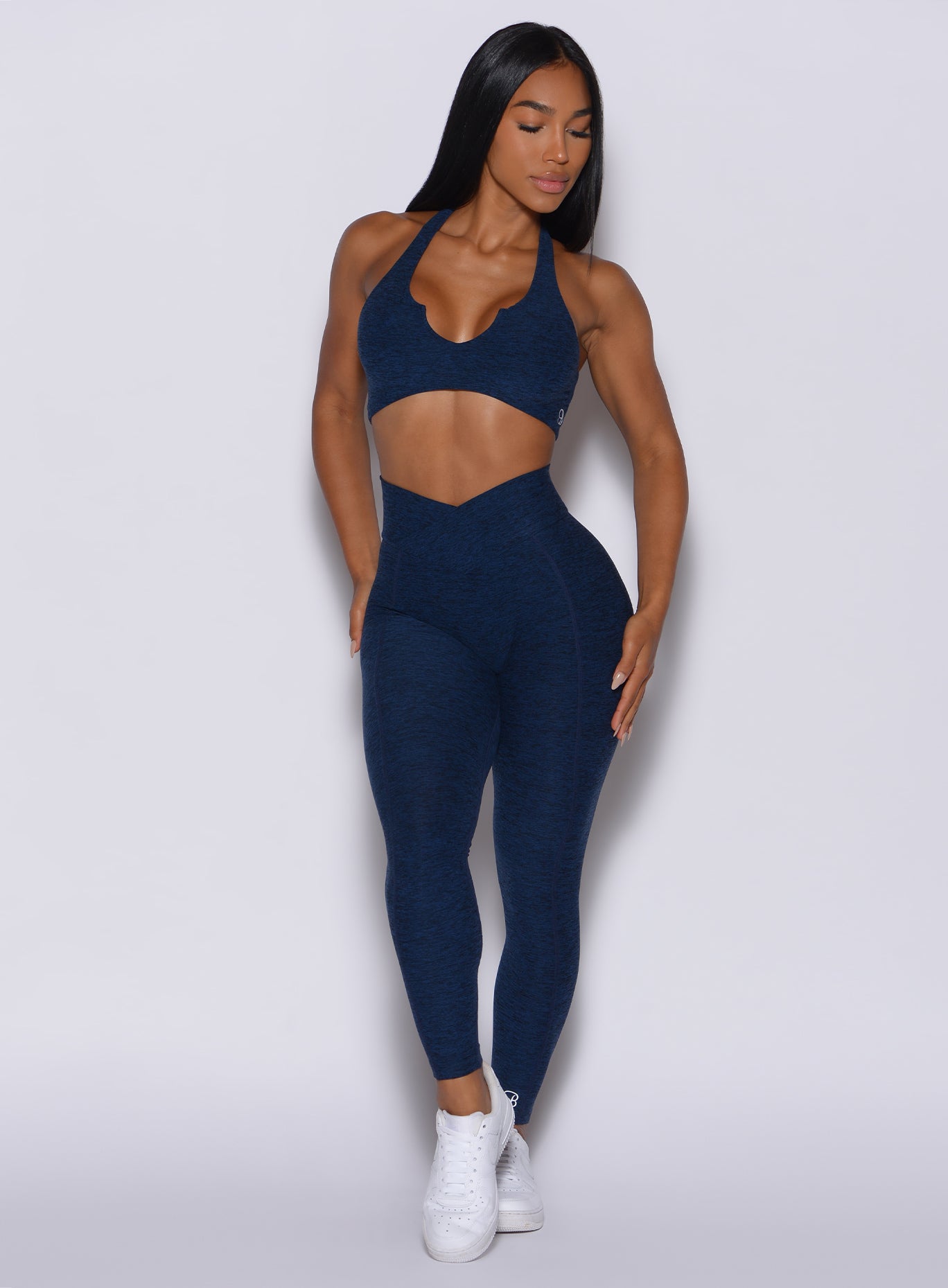 front profile view of a  model in our Brazilian Contour Leggings in sapphire blue color and a matching bra 