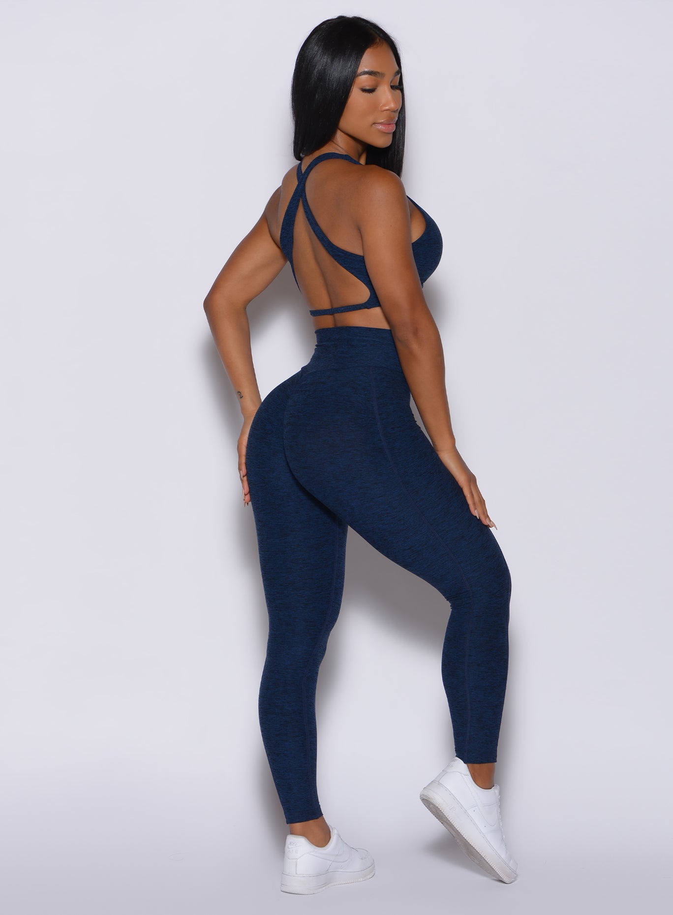 Right side  profile view of a model in our Brazilian Contour Leggings in sapphire blue color and a matching bra