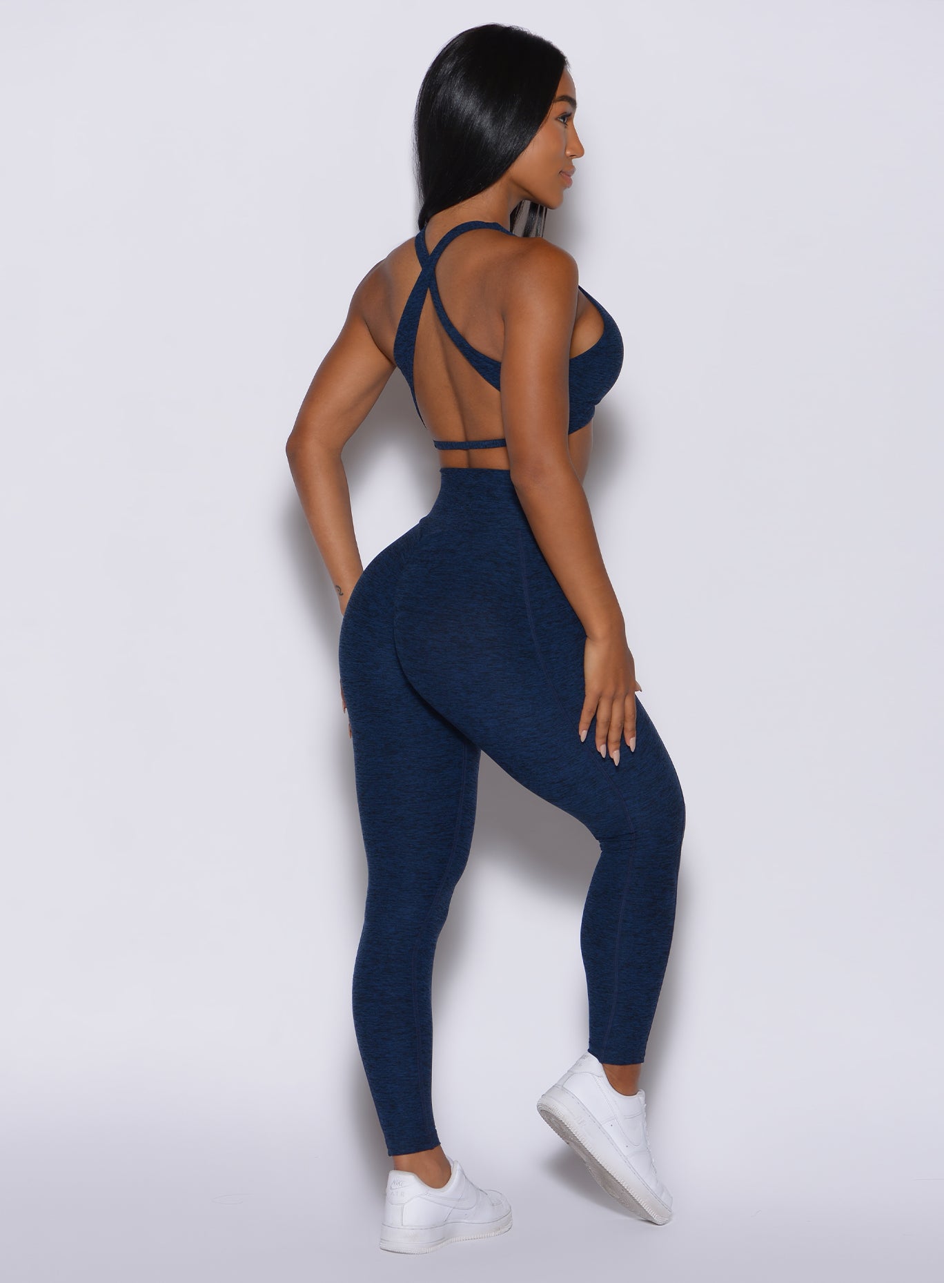 Back  profile view of a model in our Brazilian Contour Leggings in sapphire blue color and a matching sportsbra