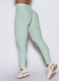 a detailed close up left side view of a model wearing the built leggings in soft aloe color