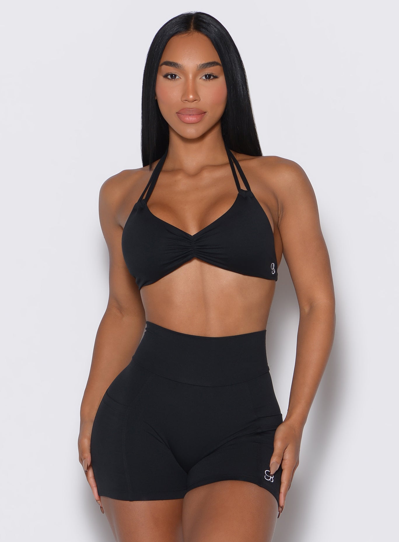 front profile view of a model wearing our black Butterfly Sports Bra along with a matching shorts 