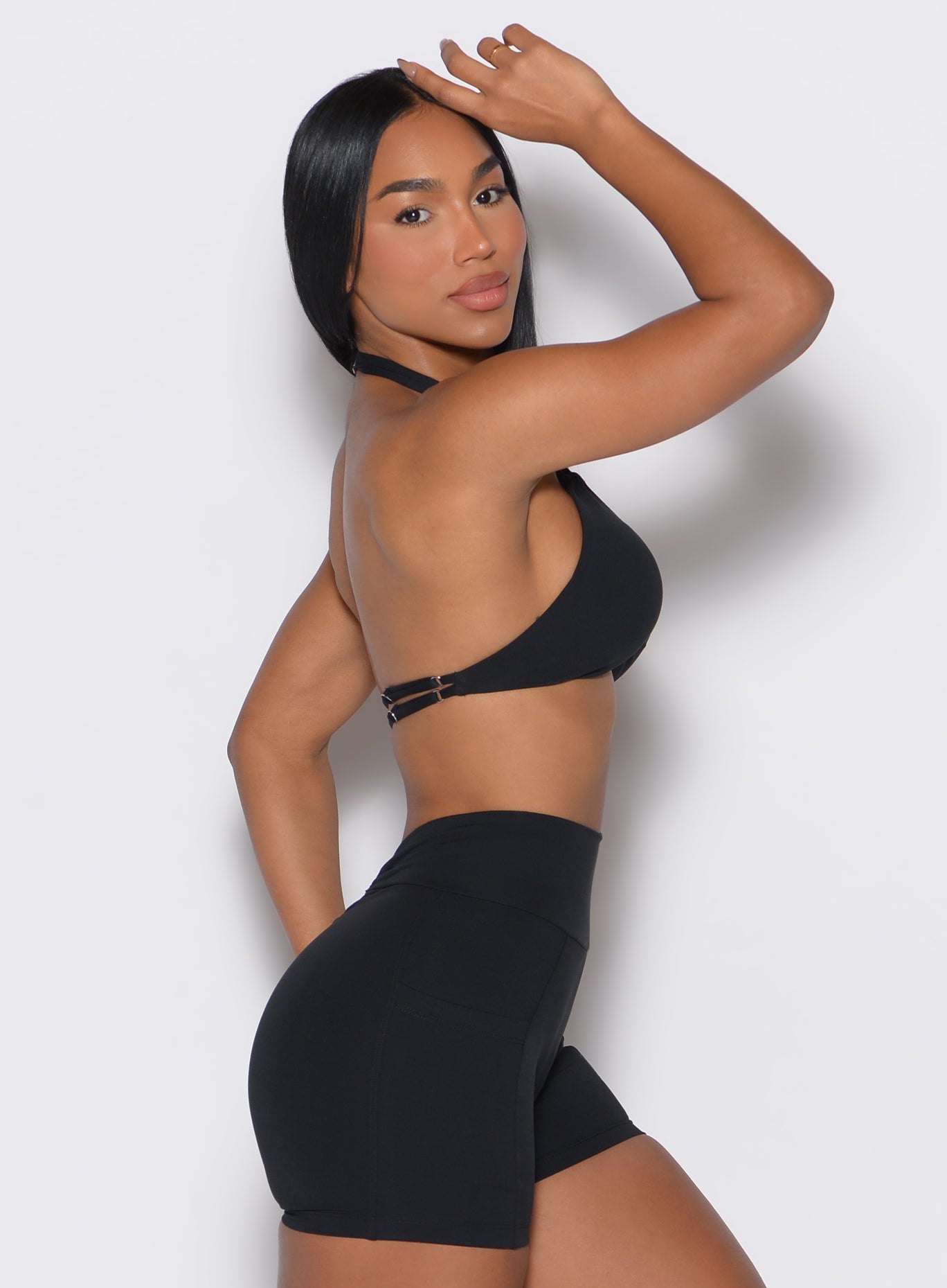 right side profile view of a model wearing our black Butterfly Sports Bra along with a matching shorts