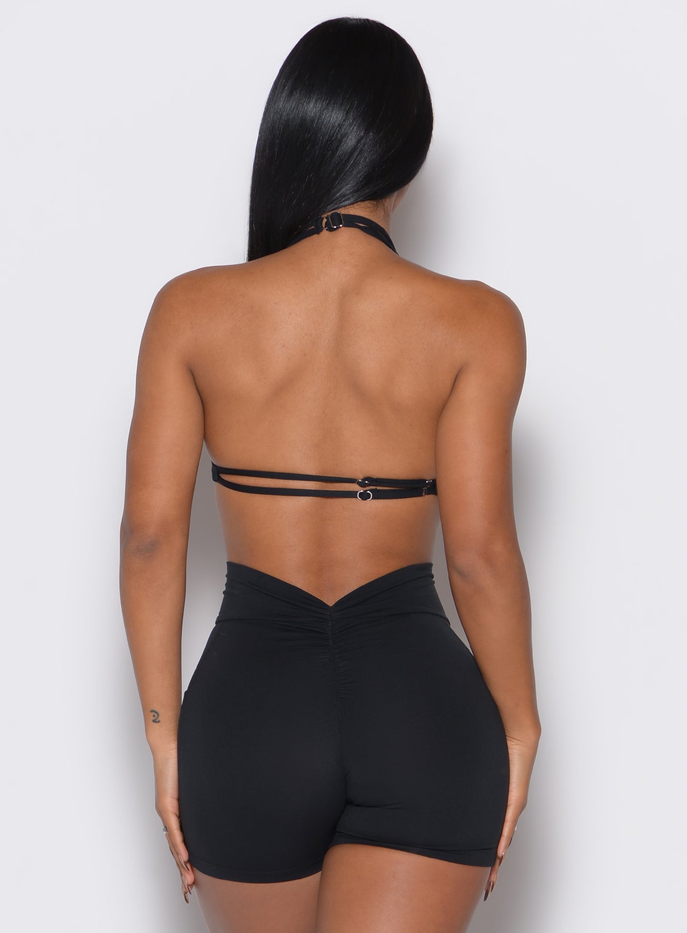 back profile view of a model wearing our black Butterfly Sports Bra along with a matching shorts