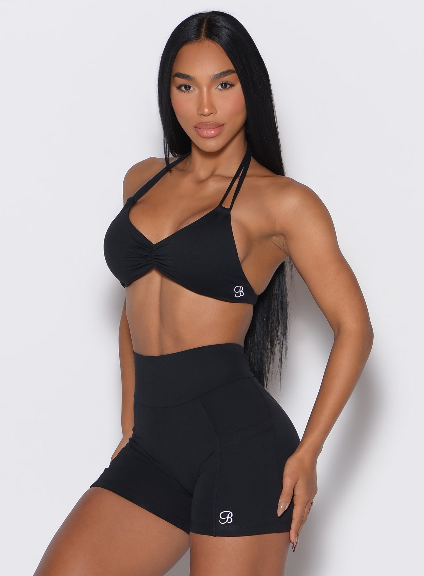 front profile view of a model facing forward  our black Butterfly Sports Bra along with a matching shorts