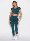 front profile view of a model wearing the Cargo Edge Leggings in dark sea color paired with the matching tee