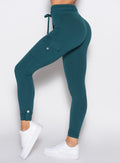 close up left side profile shot of a model wearing the Cargo Edge Leggings in dark sea color
