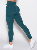 close up back left side profile shot of a model wearing the Cargo Edge Leggings in dark sea color