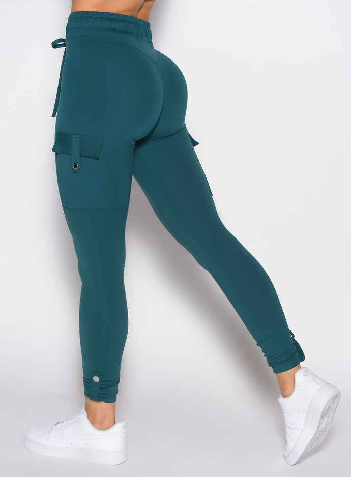 close up back left side profile shot of a model wearing the Cargo Edge Leggings in dark sea color