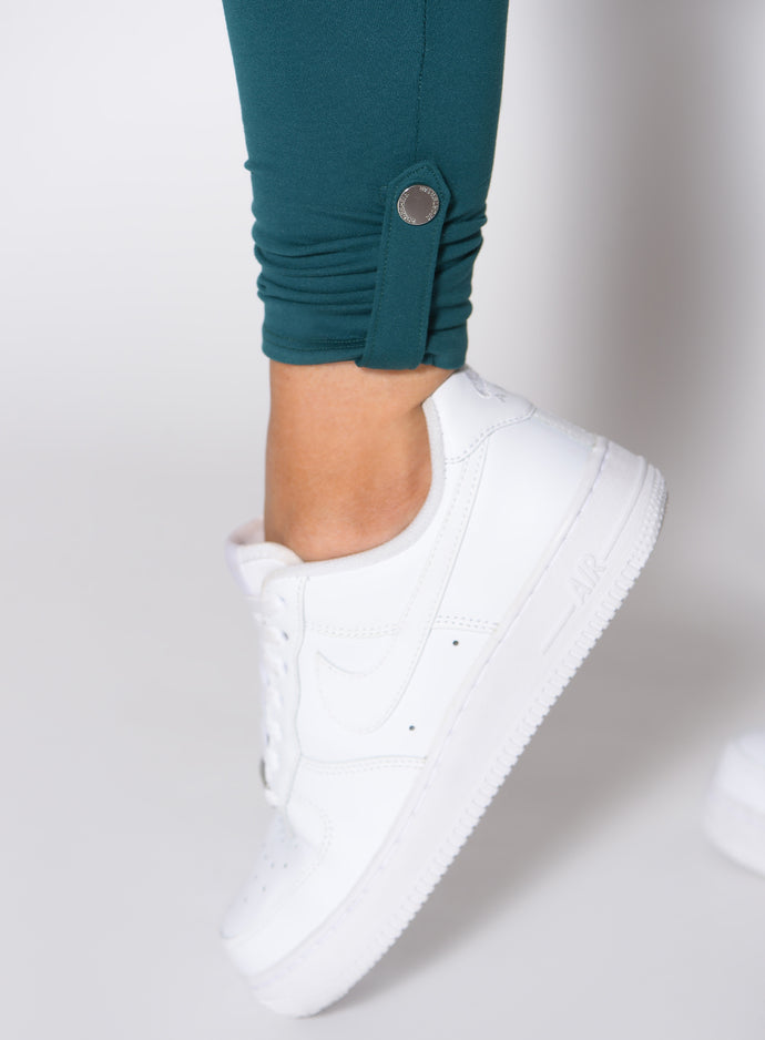 close up shot of the ankle side snap on the Cargo Edge Leggings in dark sea color