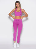 front profile view of a model wearing the Cargo Edge Leggings in hyper violet color paired with the matching bra