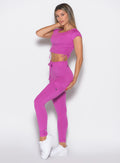 front left side profile view of a model wearing the Cargo Edge Leggings in hyper violet color paired with the matching tee
