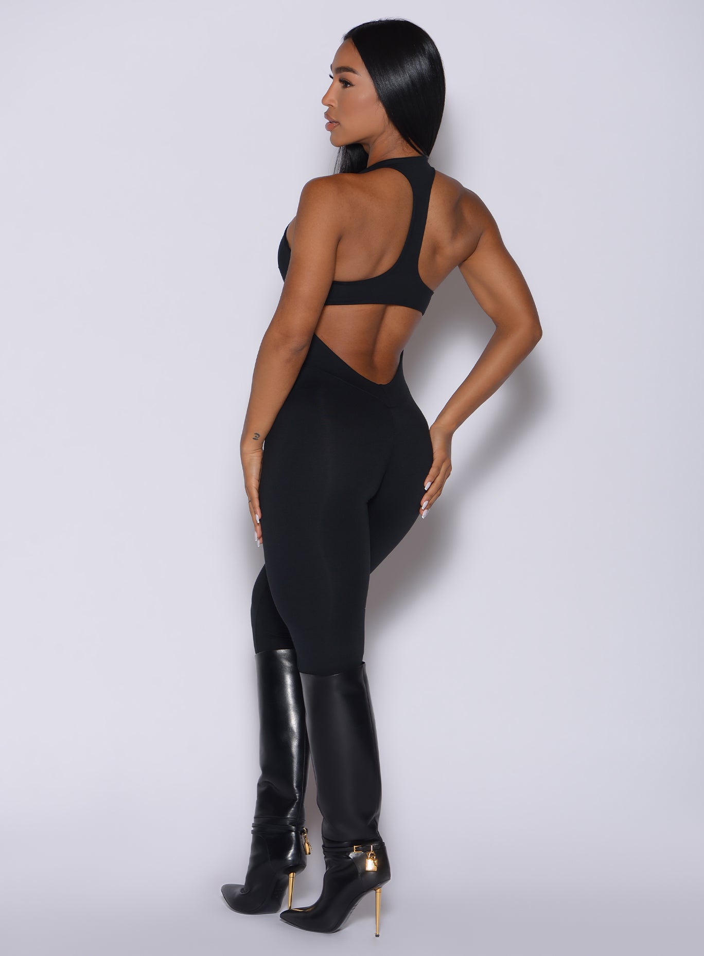 Back profile view of a model in our black zip bodysuit 