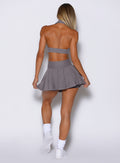 back profile view of a model wearing the Champion Skort in Champion Gray color 