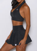 close up left side profile view of a model wearing the Champion Skort in Charcoal color 