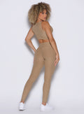 back side profile view of a model wearing the Charm Fit Leggings in sandstone color