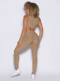 back side profile view of a model wearing the Charm Fit Leggings in sandstone color