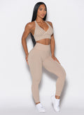 front profile view of a model wearing our cheeky seamless leggings in Timeless Taupe color along with the matching bra