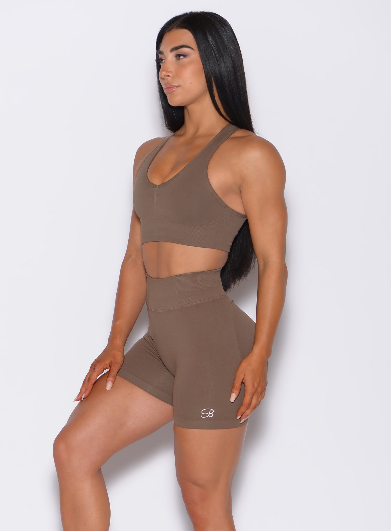 left side profile picture of a model angled slightly to her left wearing our smooth seamless bra in beachwood color along with the matching shorts