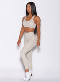 left side profile view of a model angled left wearing our shine leopard leggings in Buff Leopard color along with the matching sports bra