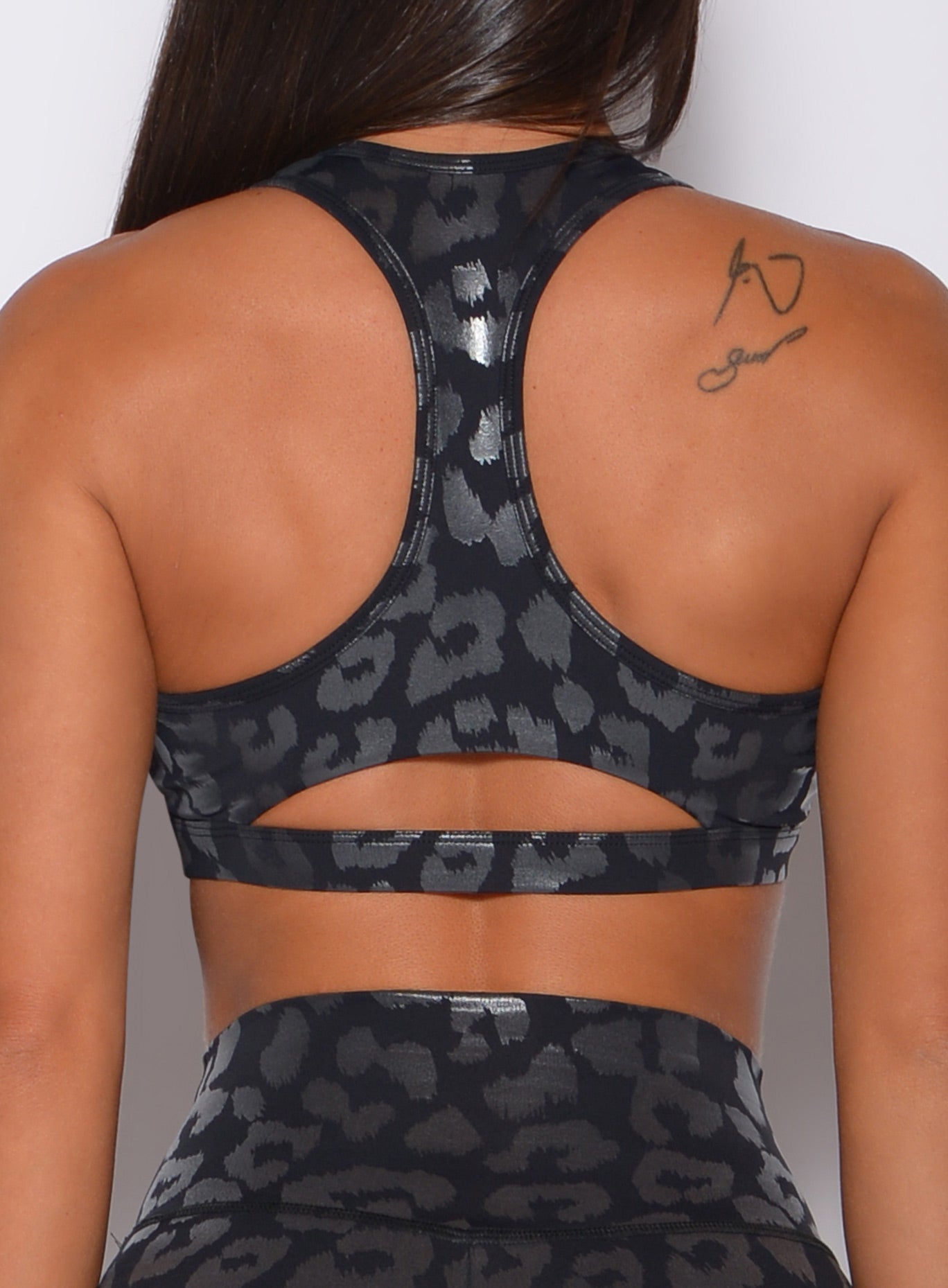 Zoomed in back profile view of a model wearing our shine leopard bra in black leopard color 