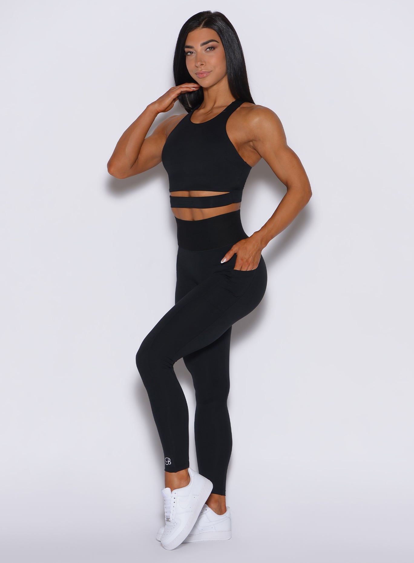 Left side profile view of a model in our black cincher leggings and a matching top