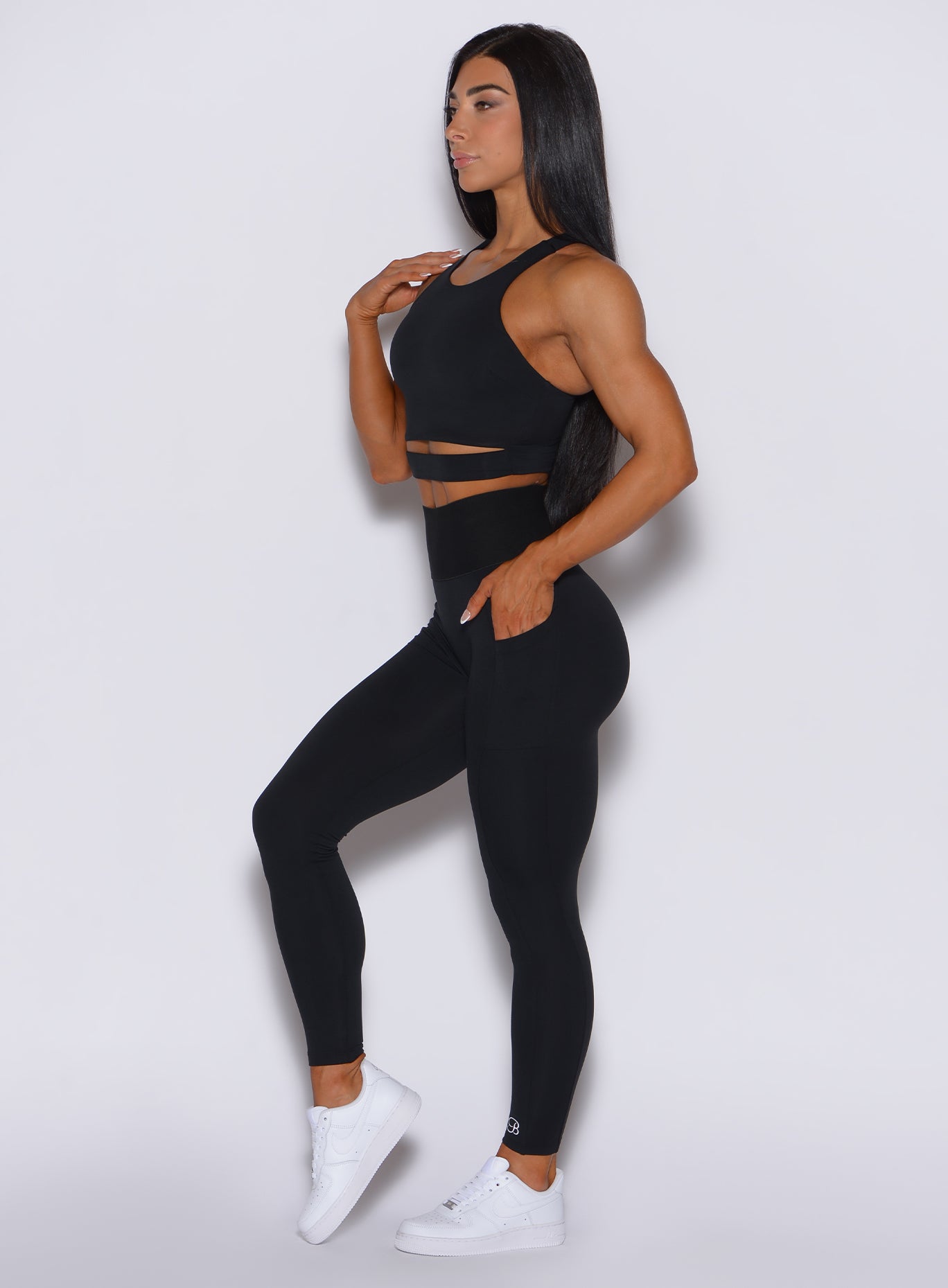 left side profile view of a model wearing our black cincher leggings and a matching top