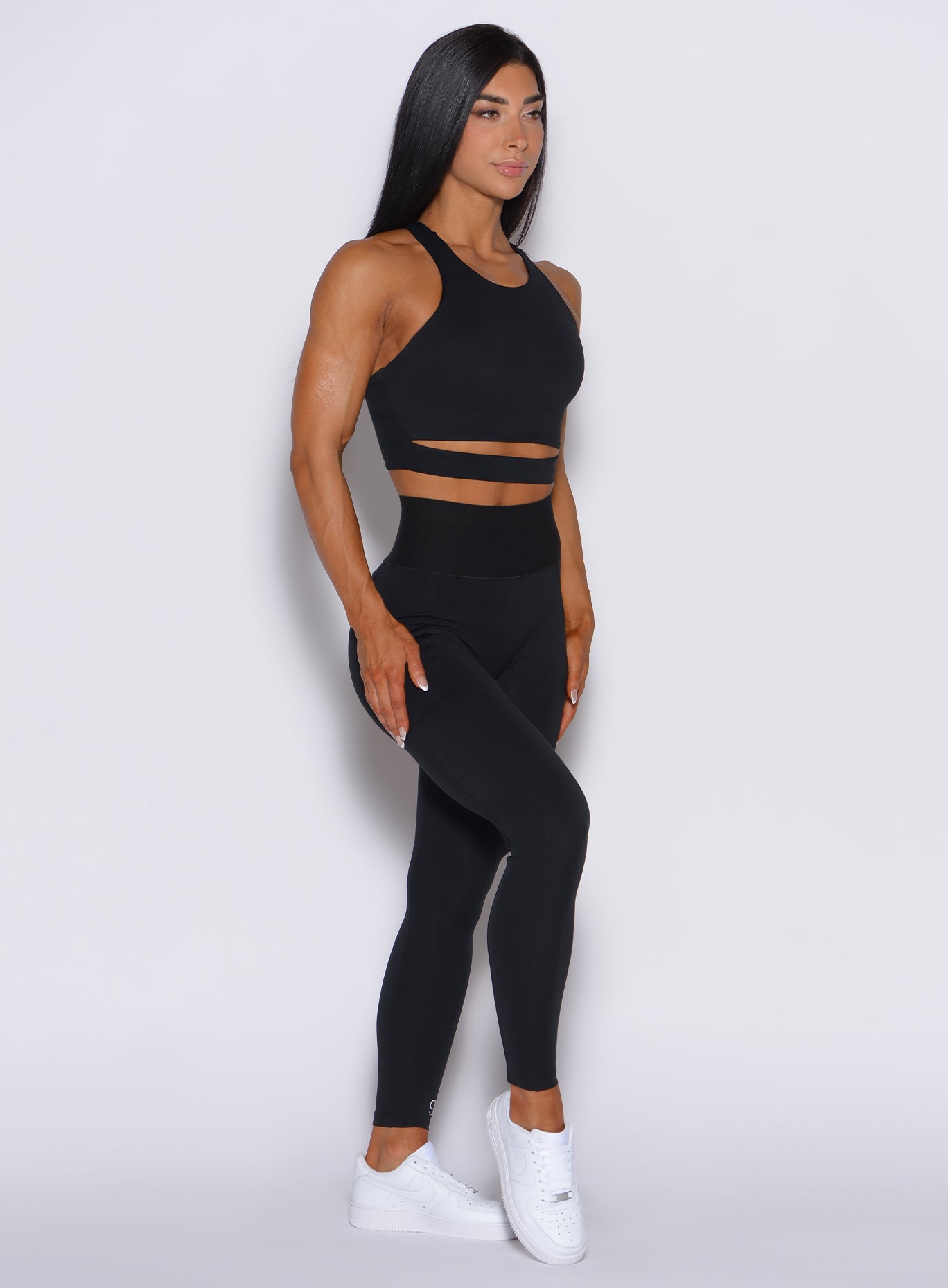 Right side profile view of a model wearing our black cincher leggings and a matching top