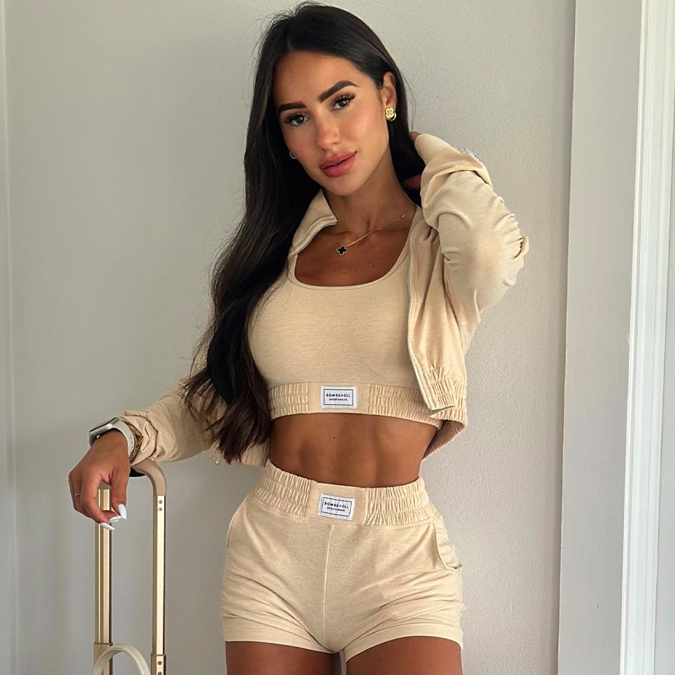 A frontal shot of the model dressed in our Vanilla Cloud crop jacket, matching shorts, and bra.