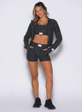 front profile view of a model with both hands inside the side pockets wearing the Cloud Comfort Shorts in Charcoal color