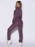 left side profile view of a model looking over her shoulder wearing the Cloud Comfort Joggers in regal purple color