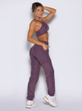 right side profile view of a model with one hand inside the side pocket wearing the Cloud Comfort Joggers in regal purple color