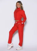 left side profile view of a model wearing the Cloud Comfort Joggers in scarlet red color paired with the matching jacket