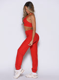 left side profile view of a model wearing the Cloud Comfort Joggers in scarlet red color paired with the matching bra 