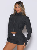 front profile view of a model wearing the Cloud Full Length Jacket in Charcoal color with the front zip closed 