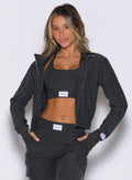 front view of a model wearing the Cloud Full Length Jacket in Charcoal color paired with the matching joggers